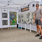 4) David James Strain, a fine artist, stands at his First Saturday Arts Market booth in September, returning October 4. (Photo by Natalie Shipula)