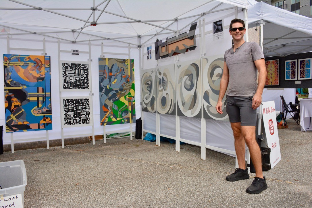 4) David James Strain, a fine artist, stands at his First Saturday Arts Market booth in September, returning October 4. (Photo by Natalie Shipula)