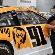 NASCAR driver Ryan Vargas and his dog Bean in front of the Lucky Dog car