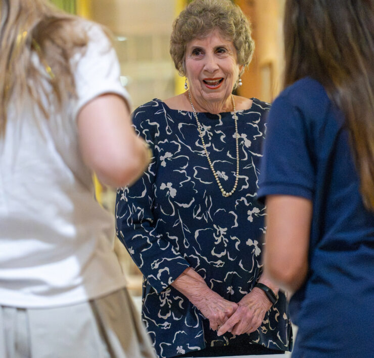 Linda Peterson, class of 1952, greeting by Lamar Seniors at the check in table