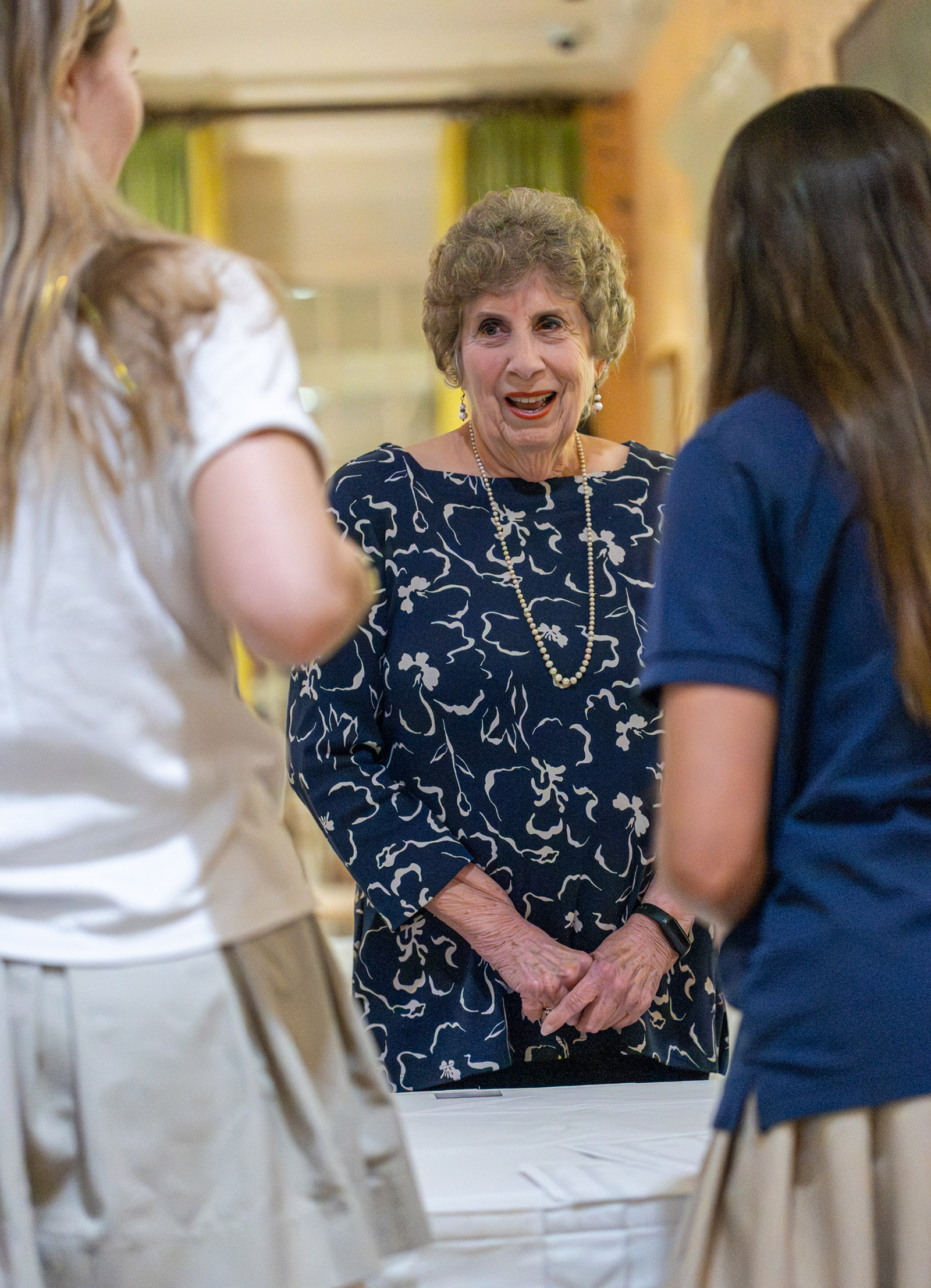 Linda Peterson, class of 1952, greeting by Lamar Seniors at the check in table